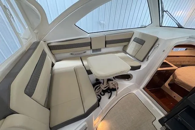  Yacht Photos Pics 2021 Pursuit OS 355 Offshore boat interior with beige seating and compact table.