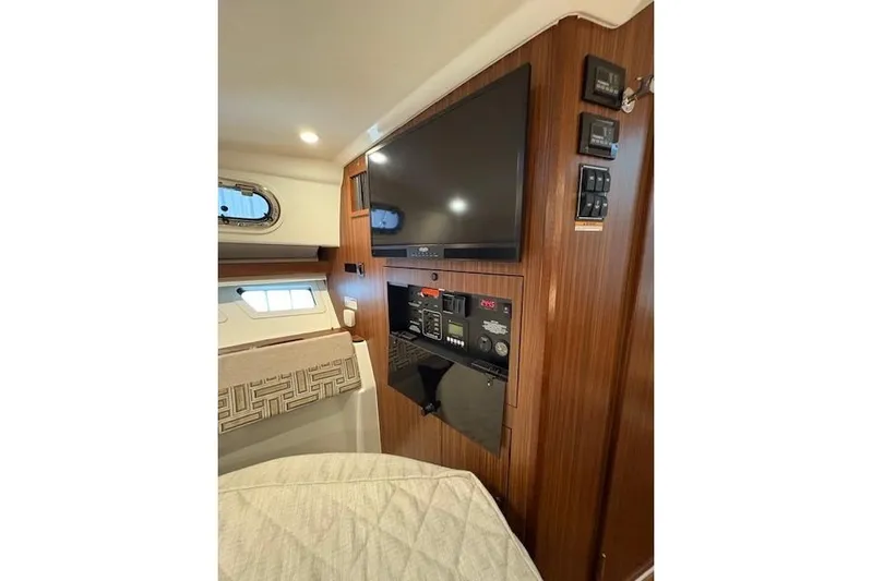  Yacht Photos Pics 2021 Pursuit OS 355 Offshore cabin interior with TV and control panel.