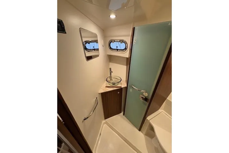  Yacht Photos Pics 2021 Pursuit OS 355 Offshore boat bathroom with modern sink and porthole window.
