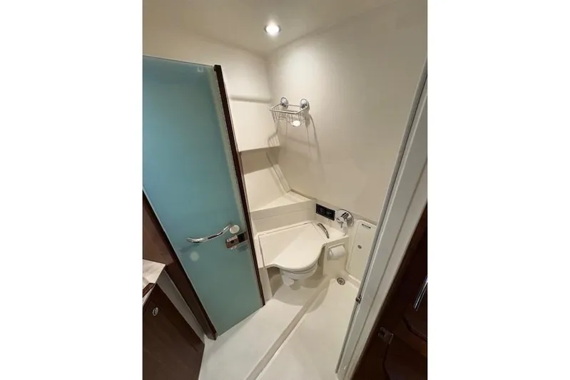  Yacht Photos Pics 2021 Pursuit OS 355 Offshore boat bathroom with modern fixtures and frosted glass door.