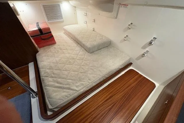  Yacht Photos Pics 2021 Pursuit OS 355 Offshore cabin with cushioned bed and wooden accents.