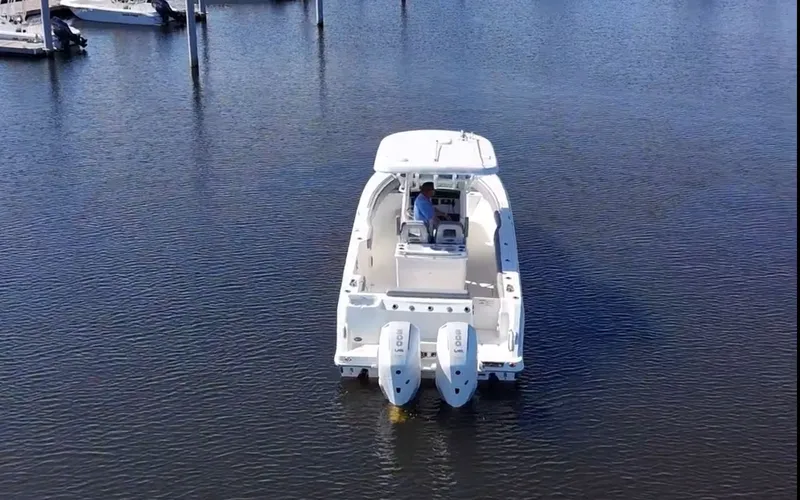  Yacht Photos Pics 2023 Boston Whaler 280 Outrage boat on calm water, rear view with dual engines.
