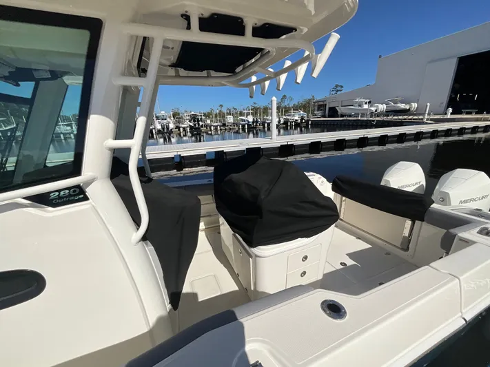  Yacht Photos Pics 2023 Boston Whaler 280 Outrage boat docked, featuring covered seating and Mercury engines.