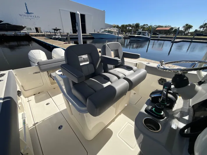  Yacht Photos Pics 2023 Boston Whaler 280 Outrage boat interior with dual seats and steering wheel at marina.