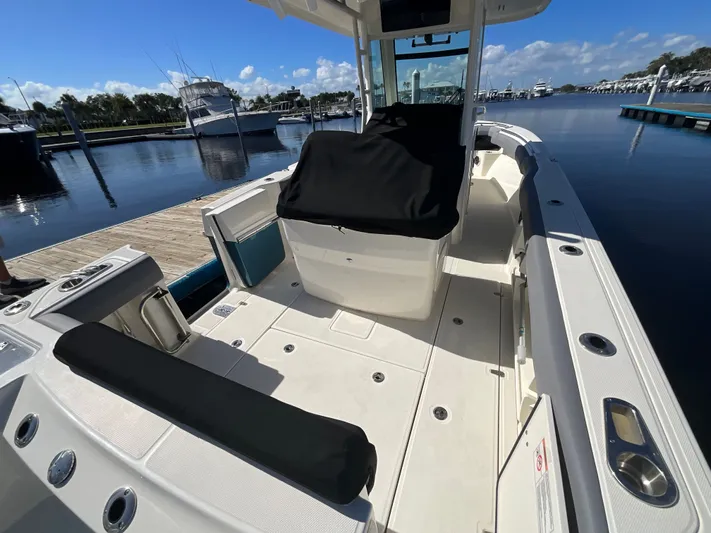  Yacht Photos Pics 2023 Boston Whaler 280 Outrage boat docked, showcasing spacious deck and seating.