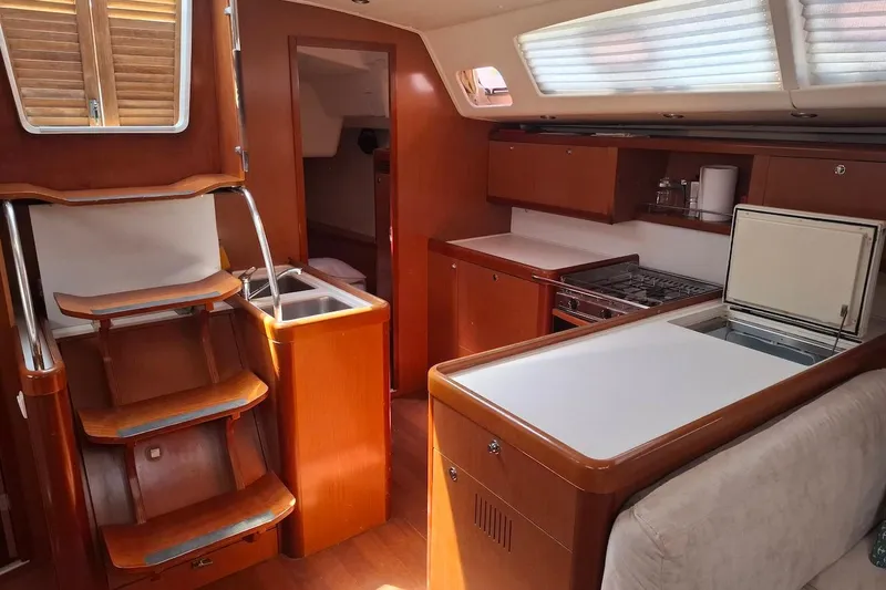  Yacht Photos Pics Interior of 2009 Beneteau Oceanis 54 yacht, featuring a modern kitchen and wooden cabinetry.