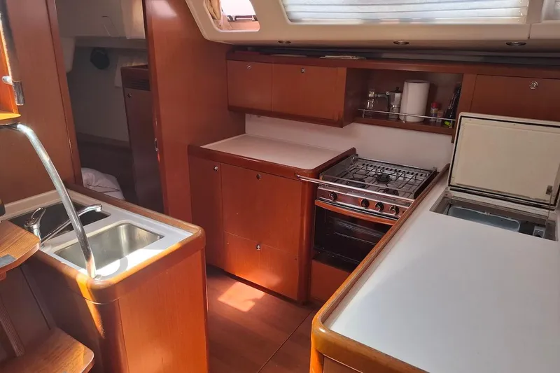  Yacht Photos Pics Interior of 2009 Beneteau Oceanis 54 yacht kitchen with stove, sink, and storage.