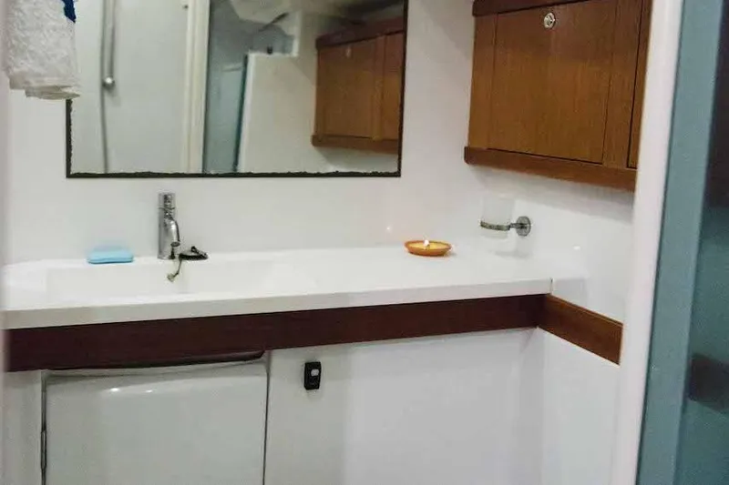  Yacht Photos Pics Bathroom interior of 2009 Beneteau Oceanis 54 yacht with wooden cabinets and mirror.