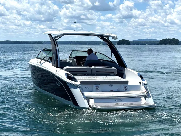  Yacht Photos Pics 2022 Cobalt R30 boat cruising on a sunny lake with scenic background.