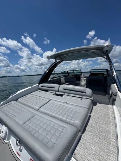  Yacht Photos Pics 2022 Cobalt R30 boat with spacious seating, under a clear blue sky on the water.