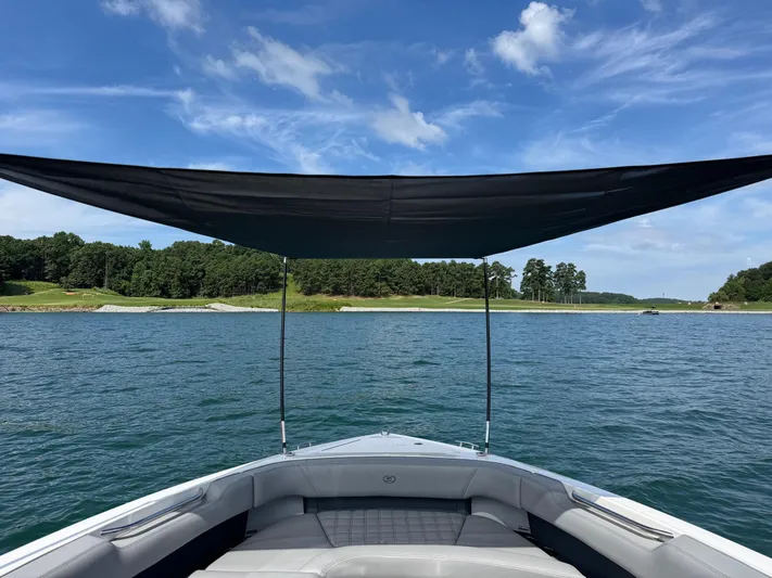  Yacht Photos Pics 2022 Cobalt R30 boat with canopy on a serene lake under a blue sky.