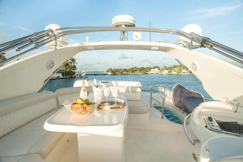  Yacht Photos Pics Luxurious 2005 Azimut 62 Evolution yacht deck with seating, table, and ocean view.