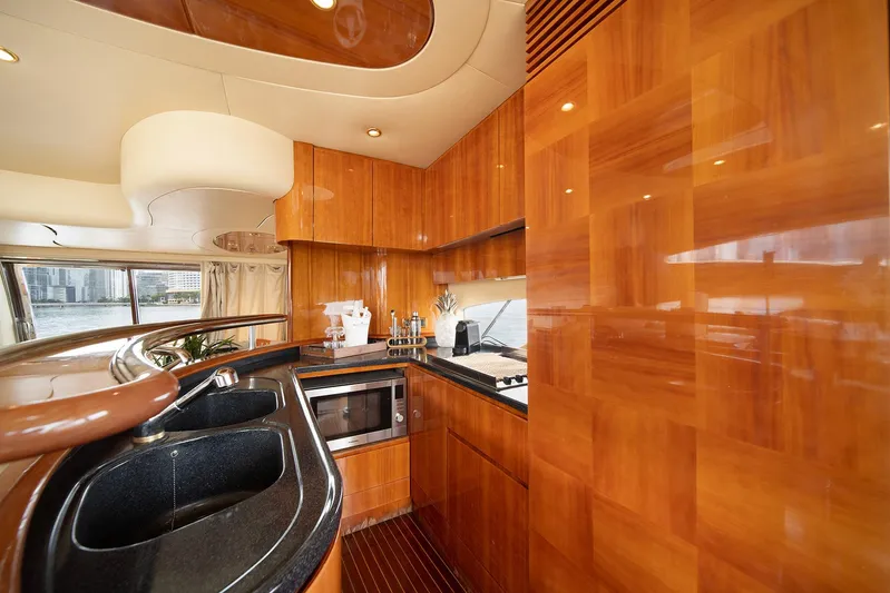  Yacht Photos Pics Luxurious kitchen interior of 2005 Azimut 62 Evolution yacht with wood cabinetry and modern appliances.