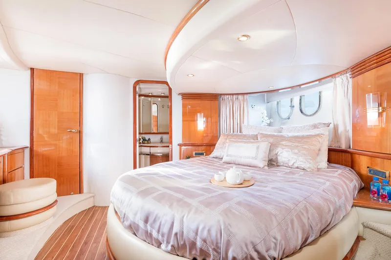  Yacht Photos Pics Luxurious bedroom interior of 2005 Azimut 62 Evolution yacht with elegant wood finishes.