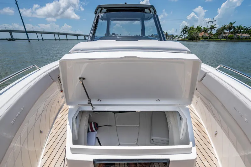 Drei Kinder Yacht Photos Pics 2023 Schaefer V33 boat with open storage compartment, docked near a bridge.