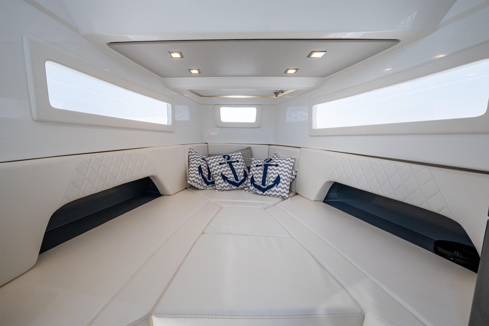 Luxurious interior of 2023 Schaefer V33 yacht with elegant seating and nautical-themed cushions.