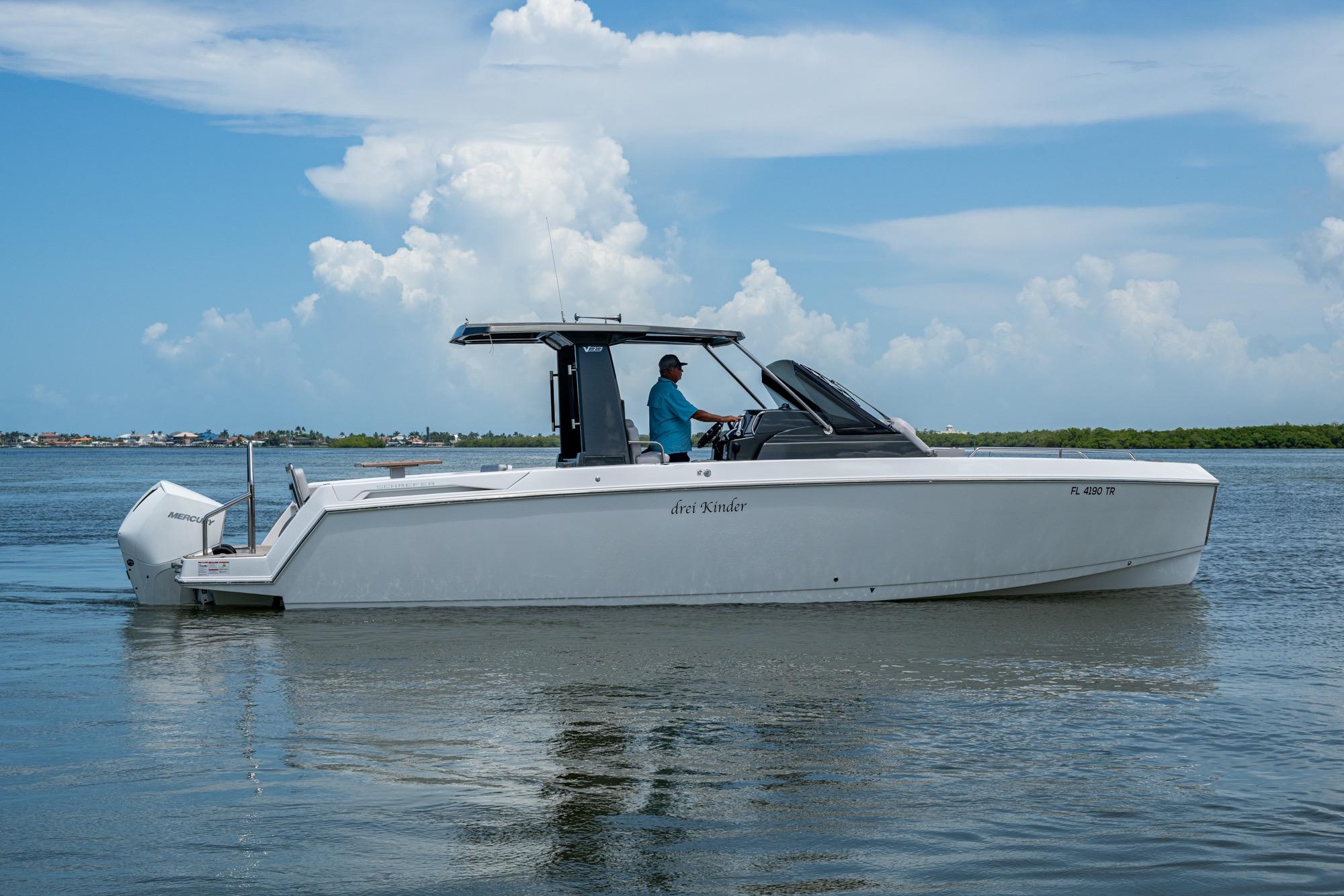 2023 Schaefer V33 boat cruising on calm water under a clear blue sky.