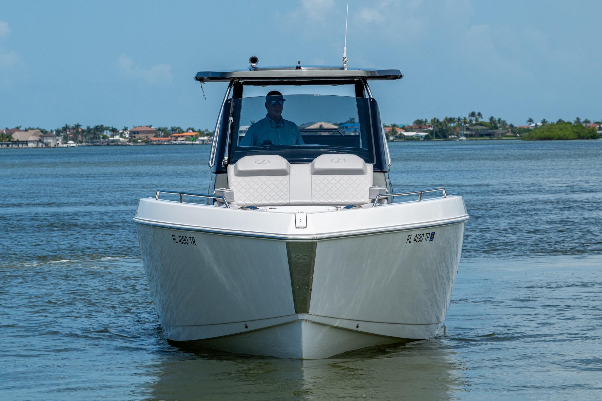 2023 Schaefer V33 boat cruising on a calm waterway, clear sky in the background.