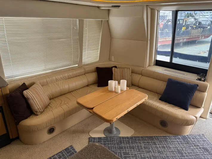 The Office Yacht Photos Pics Luxurious interior of 2001 Bayliner 5288 Pilot House Motoryacht with plush seating and wooden table.