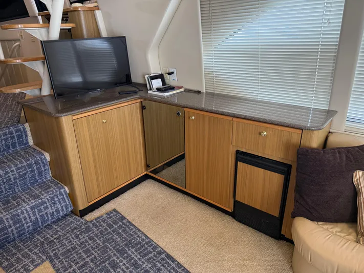 The Office Yacht Photos Pics Interior of 2001 Bayliner 5288 Pilot House Motoryacht with TV, cabinets, and stairs.