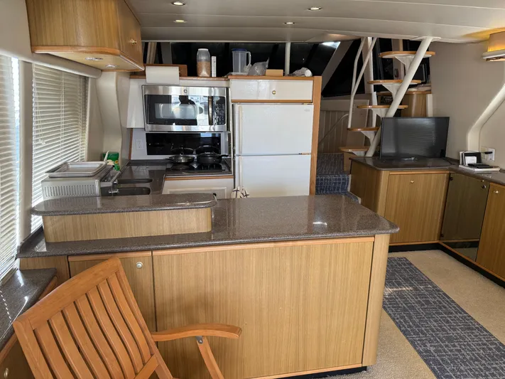 The Office Yacht Photos Pics Interior of 2001 Bayliner 5288 Pilot House Motoryacht with kitchen and seating area.