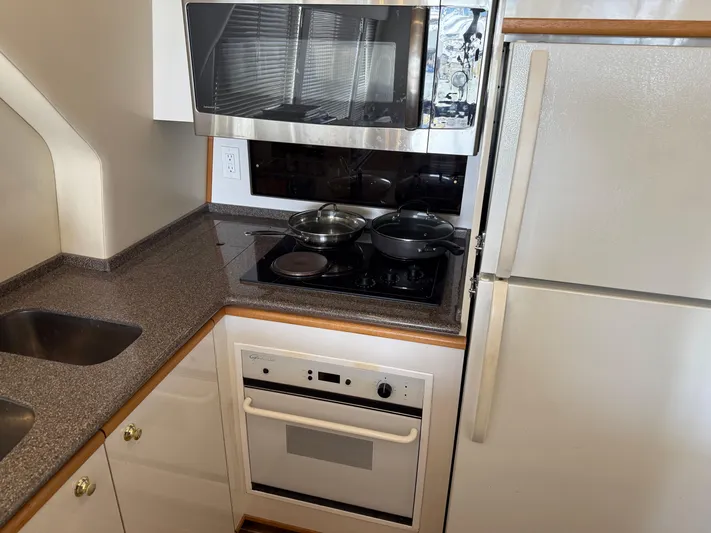 The Office Yacht Photos Pics 2001 Bayliner 5288 Pilot House Motoryacht kitchen with stove, microwave, and refrigerator.