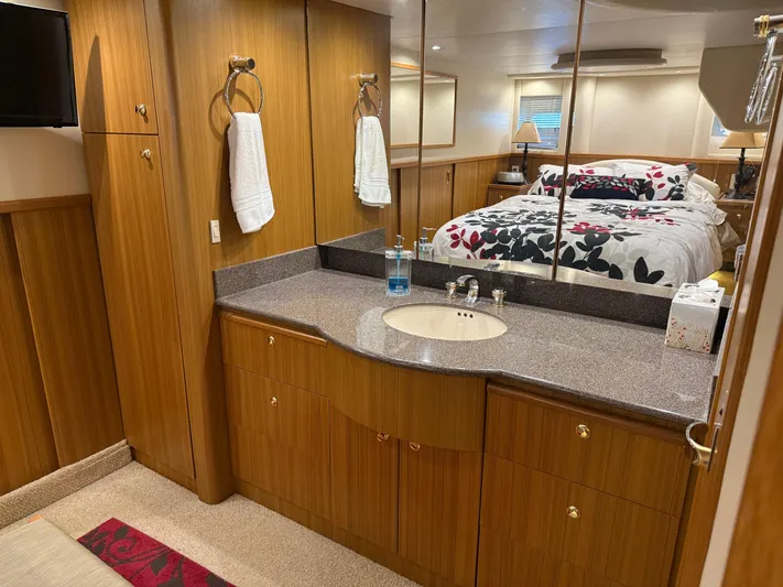 The Office Yacht Photos Pics Luxurious bathroom and bedroom in 2001 Bayliner 5288 Pilot House Motoryacht, featuring wood cabinetry.