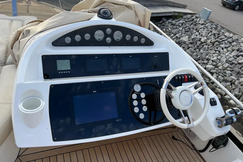  Yacht Photos Pics Control panel of a 2012 Sunseeker Manhattan 53 yacht with steering wheel and navigation displays.