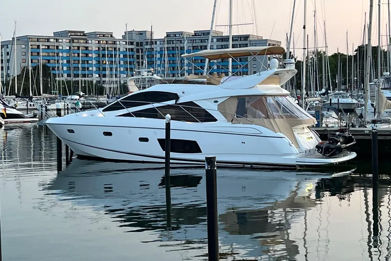  Yacht Photos Pics Luxurious 2012 Sunseeker Manhattan 53 yacht docked in a marina at sunset.