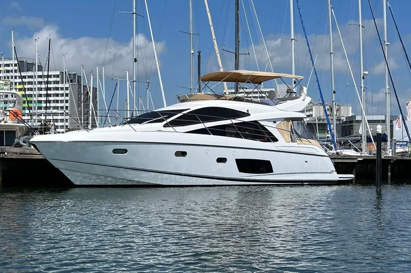  Yacht Photos Pics 2012 Sunseeker Manhattan 53 yacht docked in a marina, surrounded by sailboats.