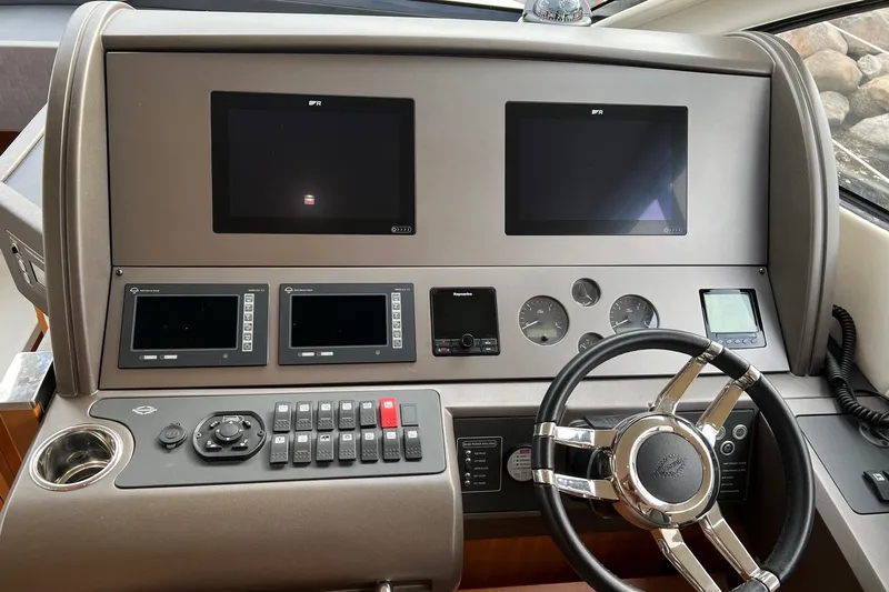  Yacht Photos Pics Control panel of 2012 Sunseeker Manhattan 53 yacht with steering wheel and navigation screens.