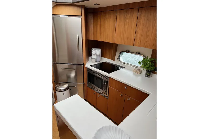  Yacht Photos Pics Modern kitchen interior on 2012 Sunseeker Manhattan 53 yacht, featuring sleek appliances and wood cabinetry.