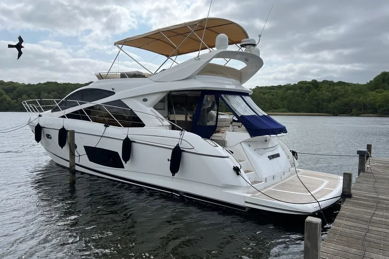  Yacht Photos Pics 2012 Sunseeker Manhattan 53 yacht docked on a serene lake with lush greenery.