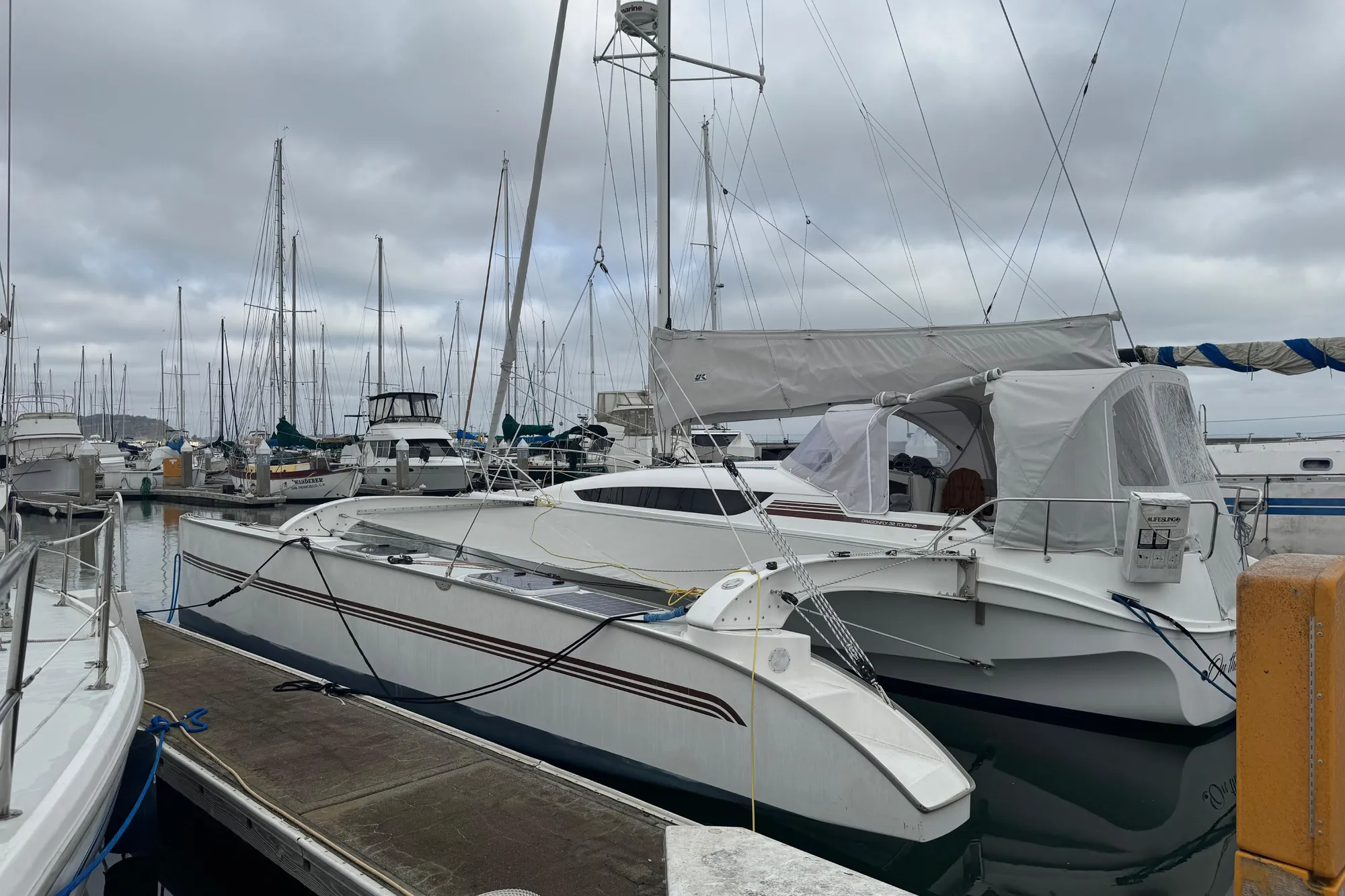 2016 Dragonfly 32 sailboat docked at a marina with overcast skies.