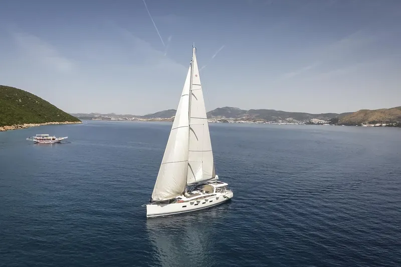  Yacht Photos Pics 2020 Jeanneau 64 sailing yacht cruising in serene coastal waters.