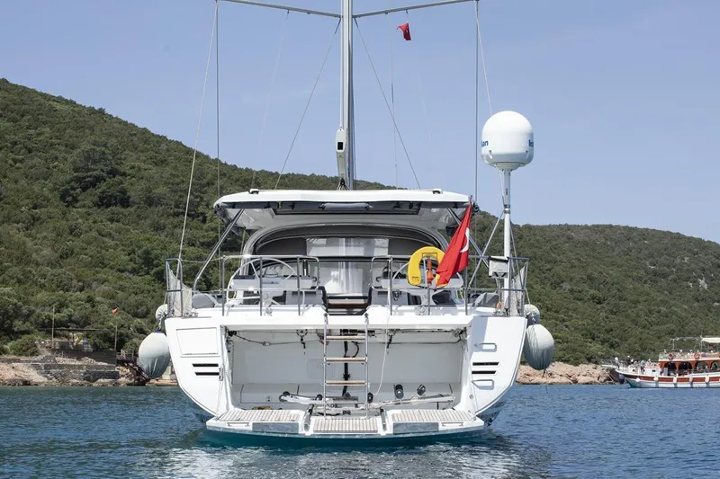  Yacht Photos Pics Jeanneau 64 yacht, 2020 model, anchored in scenic bay with lush green hills.