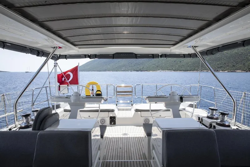  Yacht Photos Pics Luxurious 2020 Jeanneau 64 yacht deck with dual steering wheels, Turkish flag, and scenic ocean view.