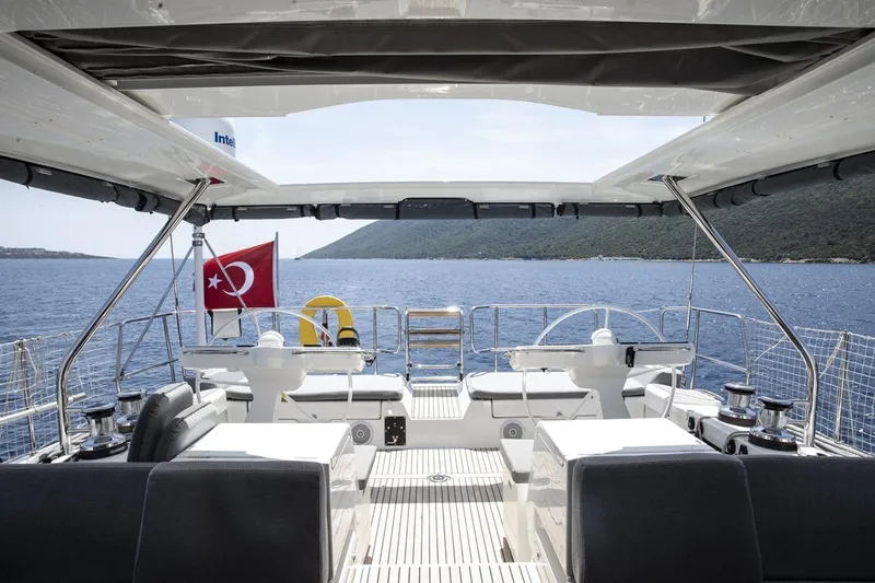  Yacht Photos Pics Jeanneau 64 yacht interior, 2020 model, with Turkish flag, overlooking serene sea and coastline.