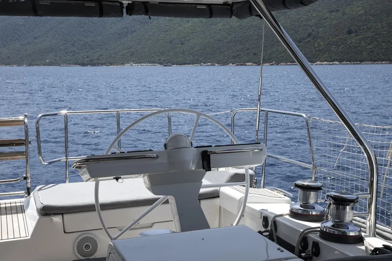 Yacht Photos Pics Cockpit view of 2020 Jeanneau 64 yacht with ocean and mountain backdrop.