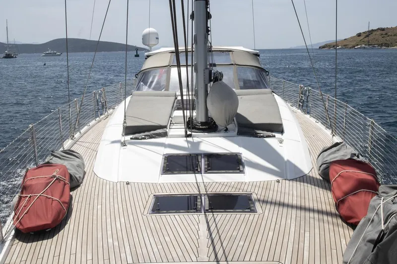  Yacht Photos Pics Jeanneau 64 yacht deck, 2020 model, sailing on calm waters with scenic coastline.
