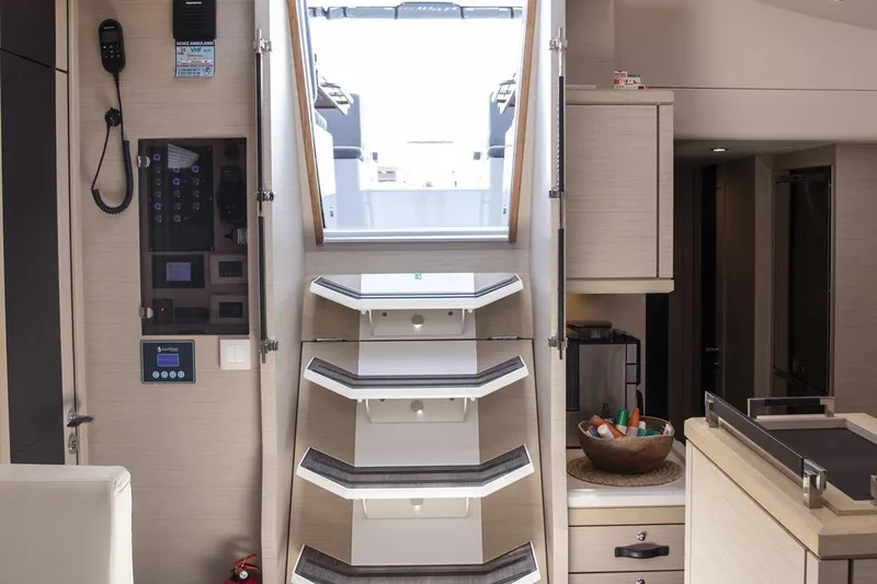  Yacht Photos Pics Interior of 2020 Jeanneau 64 yacht, featuring modern stairs and sleek cabinetry.