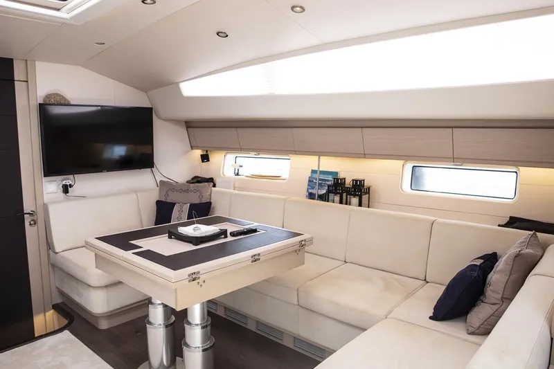  Yacht Photos Pics Luxurious interior of 2020 Jeanneau 64 yacht with modern seating and entertainment area.