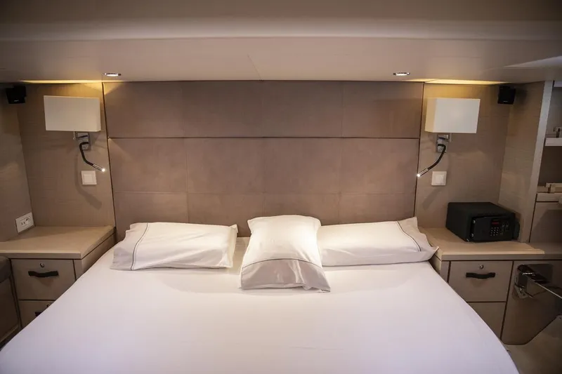  Yacht Photos Pics Luxurious bedroom interior of 2020 Jeanneau 64 yacht with modern lighting and elegant bedding.