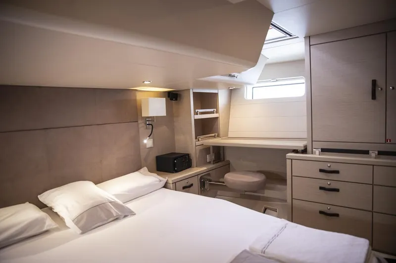  Yacht Photos Pics Luxurious cabin interior of 2020 Jeanneau 64 yacht with bed, desk, and storage.