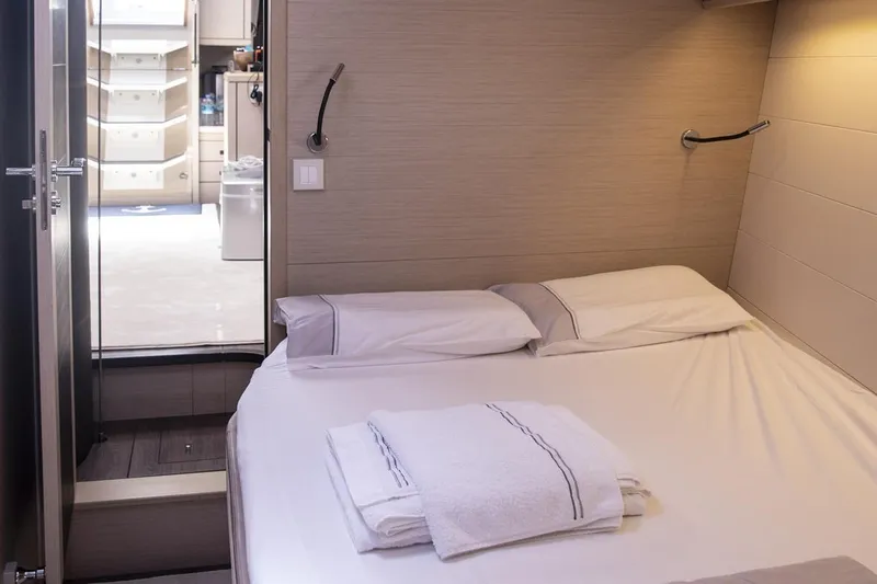  Yacht Photos Pics Luxurious cabin interior of 2020 Jeanneau 64 yacht with neatly arranged bed linens.