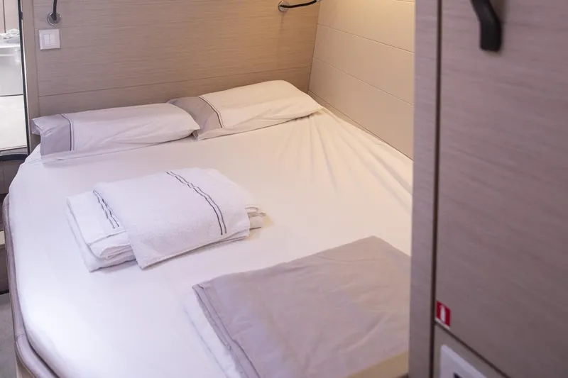  Yacht Photos Pics Luxurious cabin interior of 2020 Jeanneau 64 yacht with neatly arranged bedding.