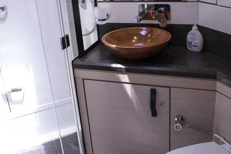  Yacht Photos Pics Luxurious bathroom interior of 2020 Jeanneau 64 yacht with modern sink and fixtures.