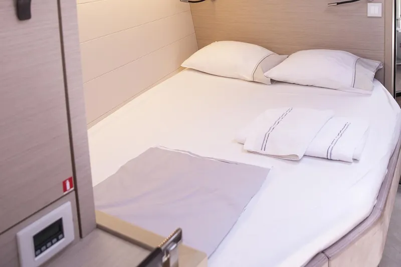  Yacht Photos Pics Luxurious cabin interior of 2020 Jeanneau 64 yacht with neatly arranged bedding.