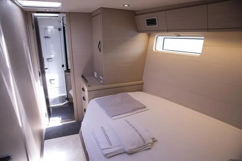  Yacht Photos Pics Luxurious cabin interior of 2020 Jeanneau 64 yacht with bed and ensuite bathroom.