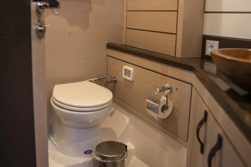  Yacht Photos Pics Luxury bathroom on 2020 Jeanneau 64 yacht with modern fixtures and wood accents.